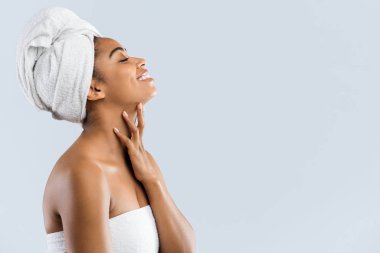 Havluya sarılı neşeli kadın fotokopi odasına bakıyor.