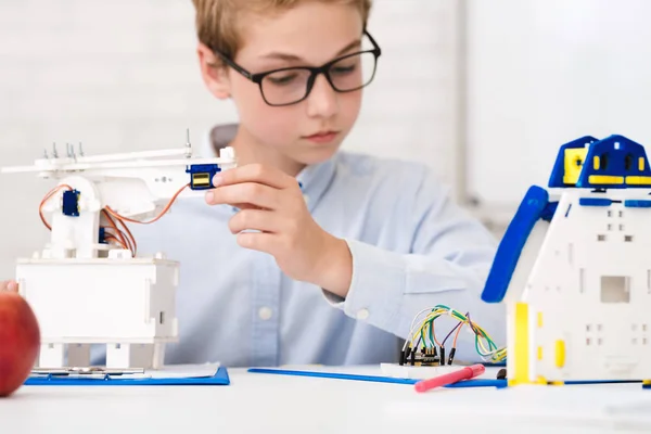 Smart schoolboy at stem lesson constructing robots — Stock Photo, Image