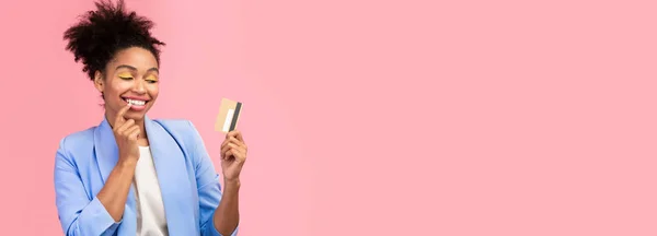 Mulher negra segurando cartão de crédito e sonhando — Fotografia de Stock