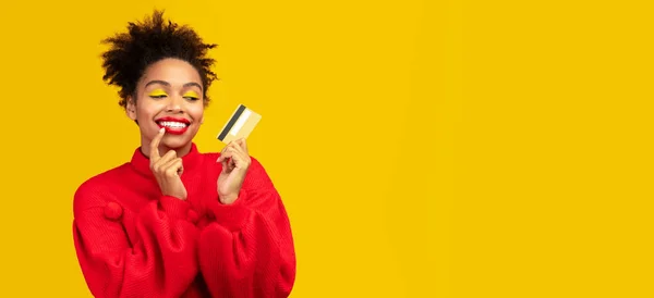 Afro girl holding credit card and thinking — Stock Photo, Image