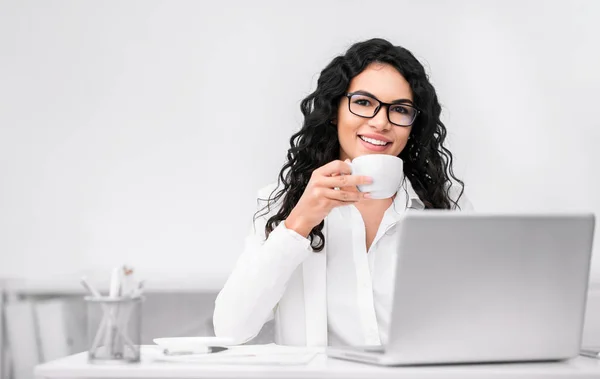 Latin woman drinking tea and using personal computer — 스톡 사진