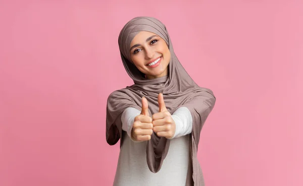 Pozytywna arabska kobieta w hidżabie i pokazywanie kciuków przed kamerą — Zdjęcie stockowe