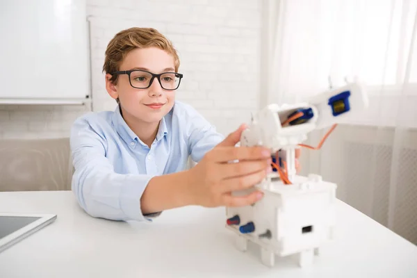 Clever schoolboy constructing robot at stem educational class — Stock Photo, Image