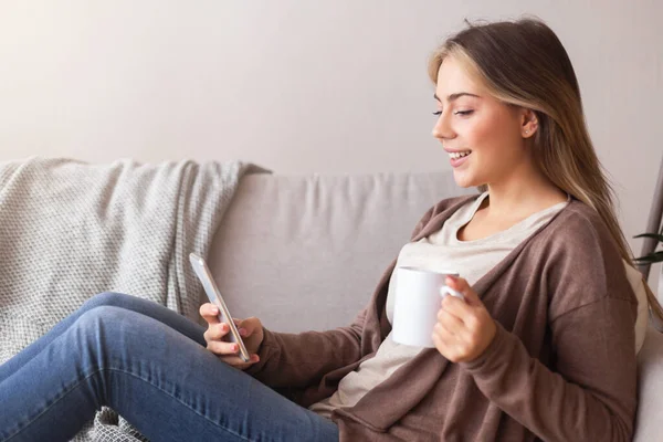 快乐的女人在家里用手机聊天喝咖啡 — 图库照片