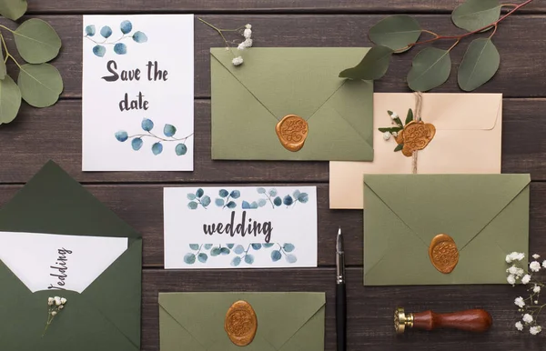 Zaproszenia ślubne, koperty, oddziały, karty na drewnianym stole — Zdjęcie stockowe