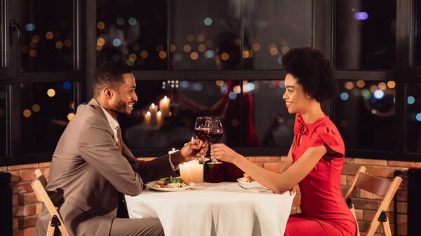 Счастливые супруги звон очков во время романтического ужина в ресторане, Панорама
