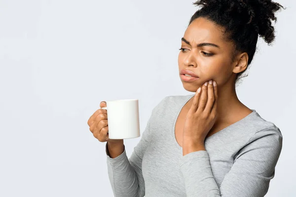 Αφρο κορίτσι που υποφέρει με ευαίσθητα δόντια, πίνοντας ζεστό τσάι — Φωτογραφία Αρχείου