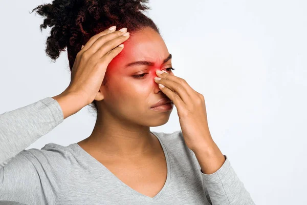 Garota negra exausta que sofre de sinusite, esfregando nariz e cabeça — Fotografia de Stock