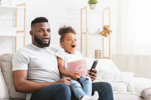 Duygusal siyah baba ve kızı birlikte film izliyorlar. — Stok fotoğraf