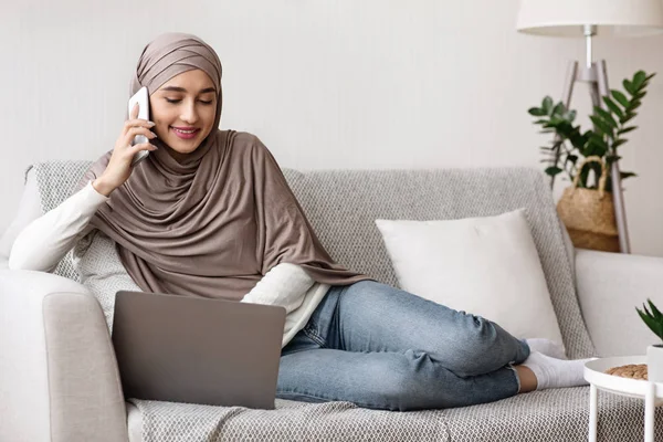 Muslim Girl Berbicara di Telepon Dan menggunakan Laptop di Rumah — Stok Foto