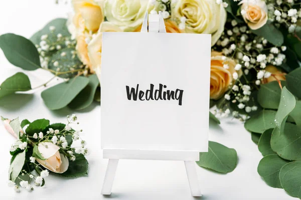 Brautstrauß aus cremefarbenen Rosen auf weißem Hintergrund mit Staffelei — Stockfoto