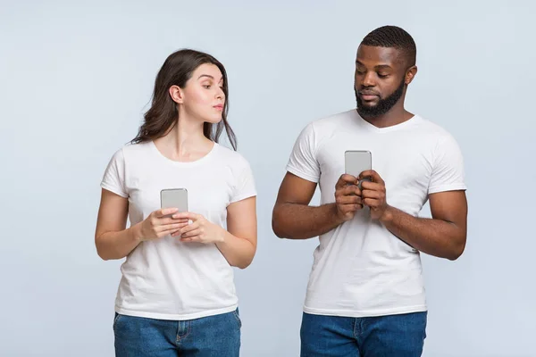 Celosa joven mujer espiando en su teléfono novios —  Fotos de Stock