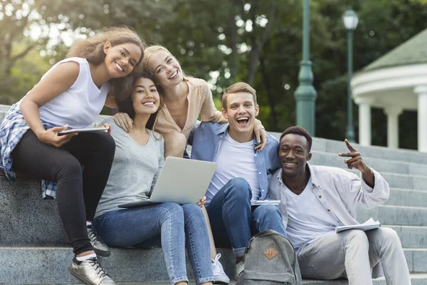 Amici felici studenti in posa mentre studiano in città — Foto Stock