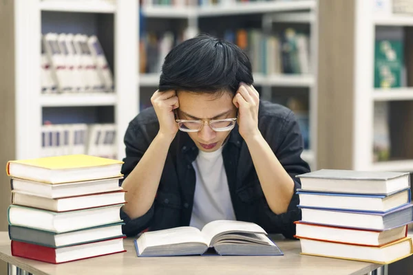 Stressad kinesisk kille förbereder sig för examination i biblioteket — Stockfoto