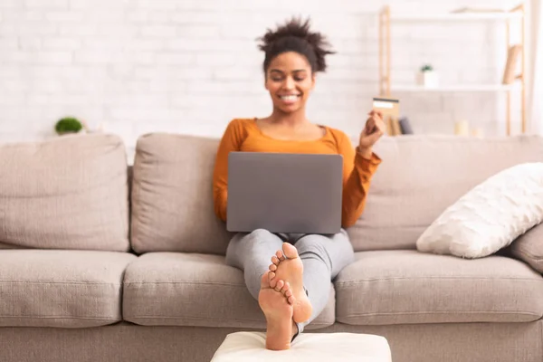 Africano menina americana fazendo compras on-line sentado no sofá interior — Fotografia de Stock