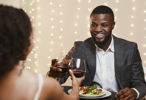 Glücklicher Afro-Mann im Anzug stößt mit seiner Freundin an — Stockfoto