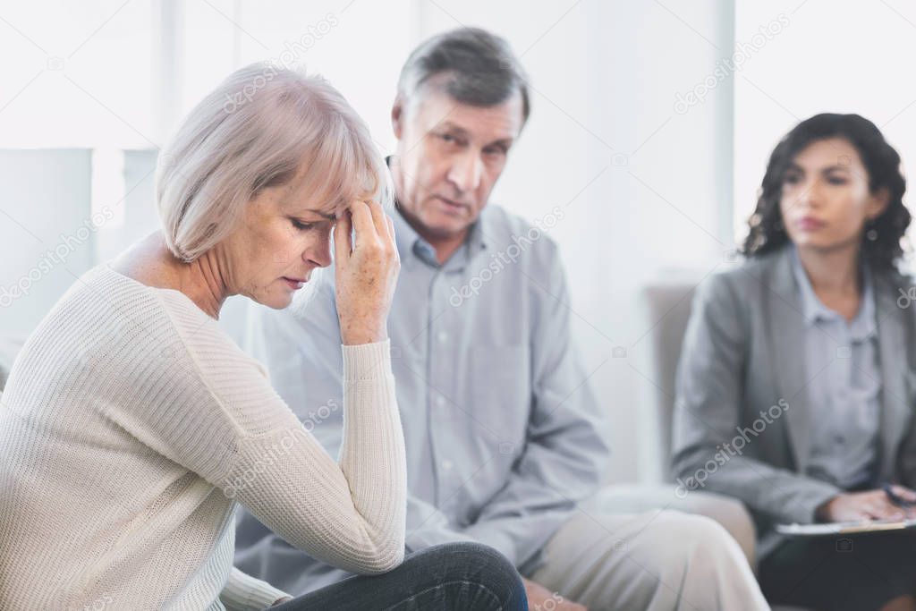 Sad husband and wife listening to psychotherapist