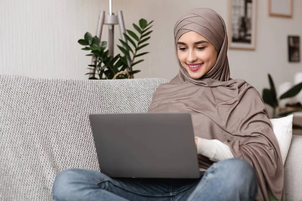 Mujer musulmana joven en hijab trabajando en el ordenador portátil en casa — Foto de Stock