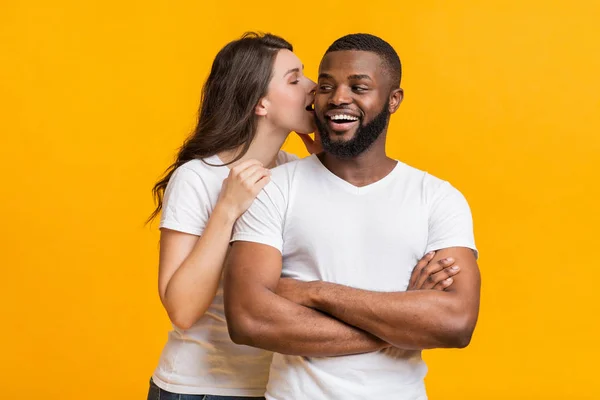 Romantisk kvinna viskar om kärlek i sina svarta pojkvänner öra — Stockfoto