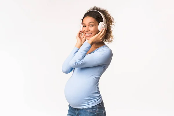 Terhesség és anyaság. Fekete terhes nő zenét hallgat — Stock Fotó