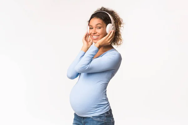 Premium Photo  Portrait of pregnant woman holding headphones on belly.  pregnancy and motherhood concept.