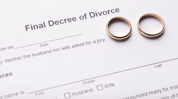 Two golden wedding rings on final divorce decree document