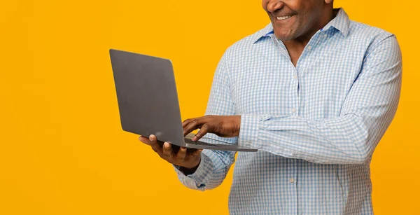 Mature african man typing on laptop, panorama — Stock Photo, Image