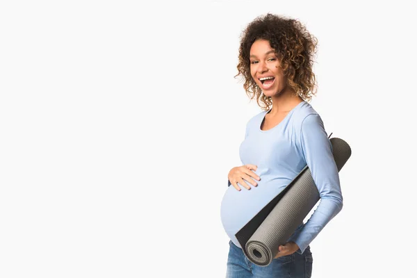 Kebugaran dan kehamilan. Wanita Afrika-Amerika memegang tikar yoga — Stok Foto