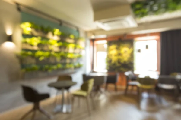 Blurred green cafe interior with living walls plants