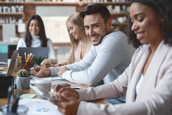 Bonito cara tomando notas na reunião de negócios do grupo — Fotografia de Stock