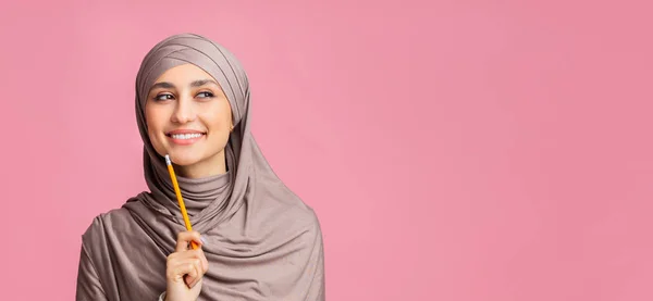 Nachdenkliche Muslimin mit Kopftuch hält Bleistift in der Hand und denkt über etwas nach — Stockfoto