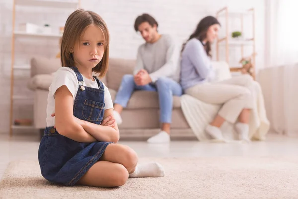 Bambina seduta separatamente da mamma e papà dopo la loro discussione — Foto Stock