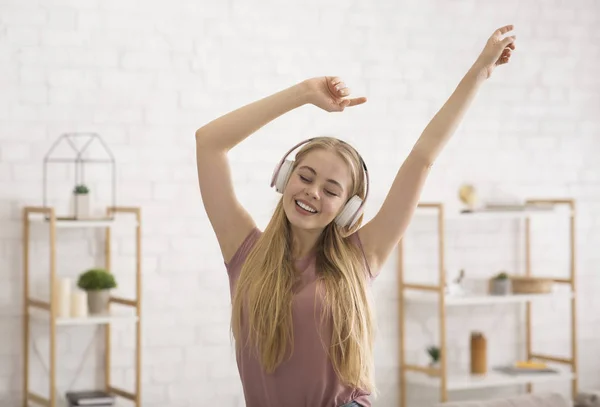 Blondýny dívka těší hudbu, pomocí bezdrátové sluchátka — Stock fotografie