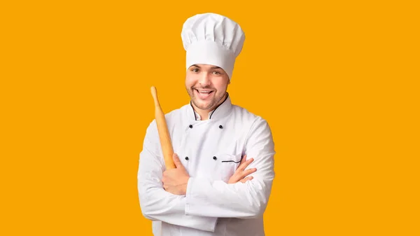 Szef kuchni trzyma Rolling Pin stojąc na żółtym tle, Panorama — Zdjęcie stockowe