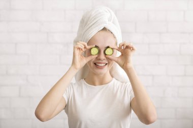 Kafasında havlu olan kadın gözlerini salatalık dilimleriyle kapadı.