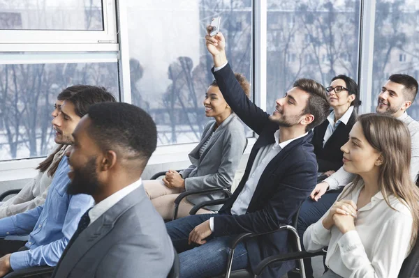 Young entrepreneur filming business lecture on phone — Stockfoto