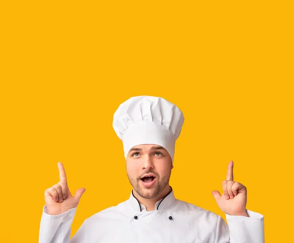 Cook Man apontando os dedos para cima sobre fundo amarelo, Studio Shot — Fotografia de Stock