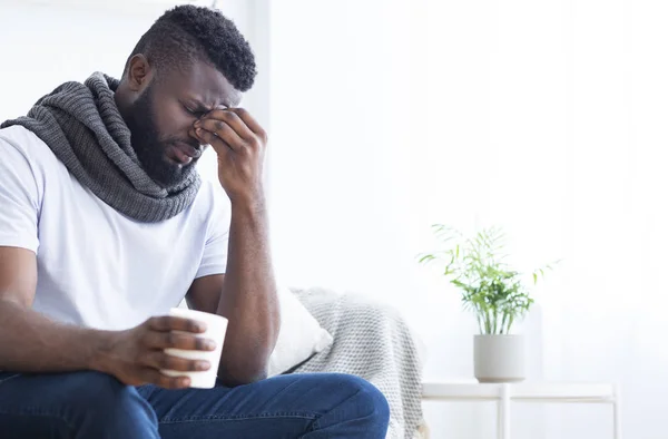 Zieke Afrikaanse man die hete thee drinkt, hoofdpijn heeft — Stockfoto