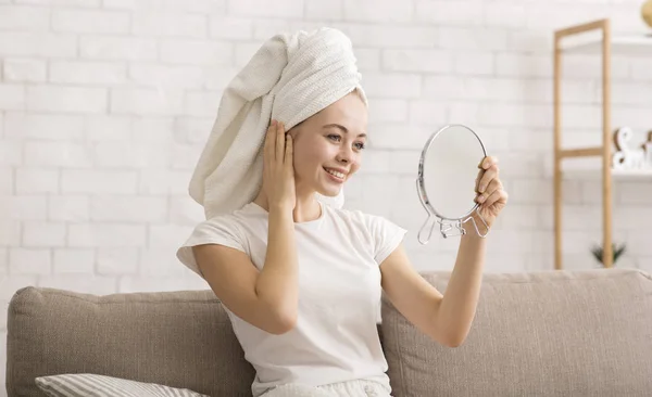 Γυναίκα κοιτάζει τον καθρέφτη, φορώντας πετσέτα στο κεφάλι μετά το ντους — Φωτογραφία Αρχείου