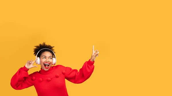 Портрет возбуждённой чёрной девушки, наслаждающейся музыкой — стоковое фото