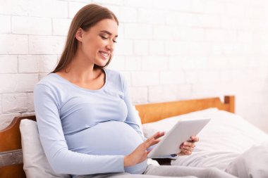 Mutlu Hamile Kız Evde Yatakta Tablet Kullanıyor