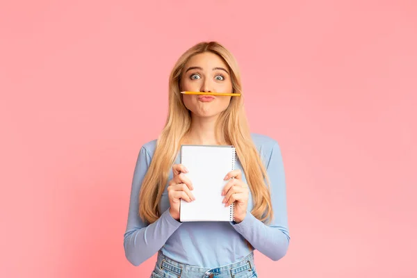 Jublande tonåring håller pennan som mustasch över rosa vägg — Stockfoto