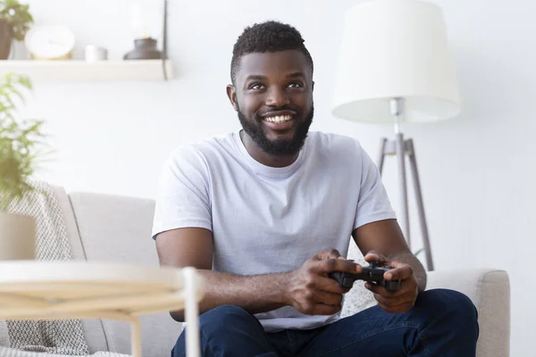 Afrikanisch-amerikanischer Spieler spielt zu Hause auf Gamepad — Stockfoto