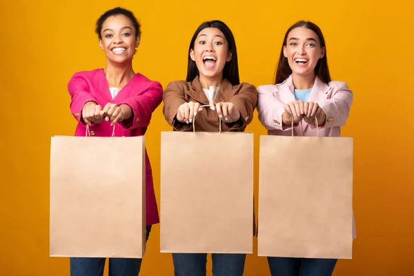 Tre glada kvinnor visar blanka Shopper väskor stående, Studio Skott — Stockfoto