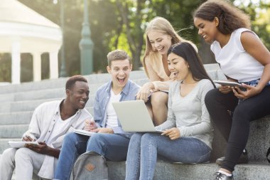 Heyecanlı arkadaşlar test sonuçlarını internetten kontrol ediyorlar, dizüstü bilgisayar kullanıyorlar