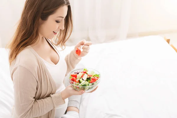 Весела вагітна леді, що обідає зі свіжим здоровим салатом вдома — стокове фото