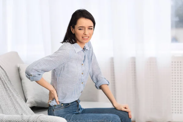 Young woman suffering from pain in lower back — Stock Photo, Image