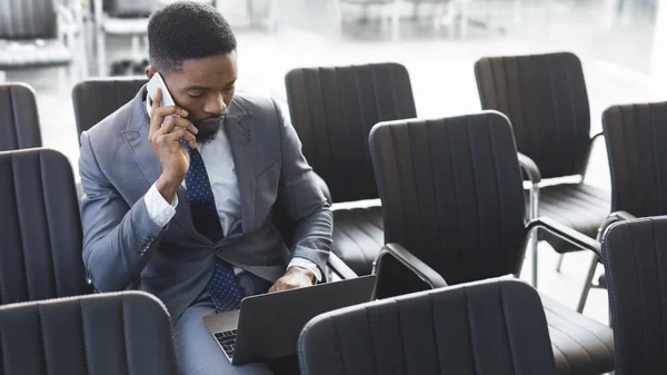 Homme d'affaires afro concentré travaillant sur un ordinateur portable dans une salle de conférence vide — Photo