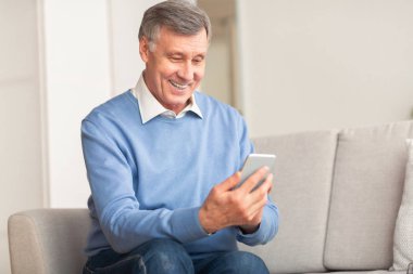 Neşeli Üst Düzey Beyefendi Koltukta Otururken Cep Telefonu Mesajı Kullanıyor