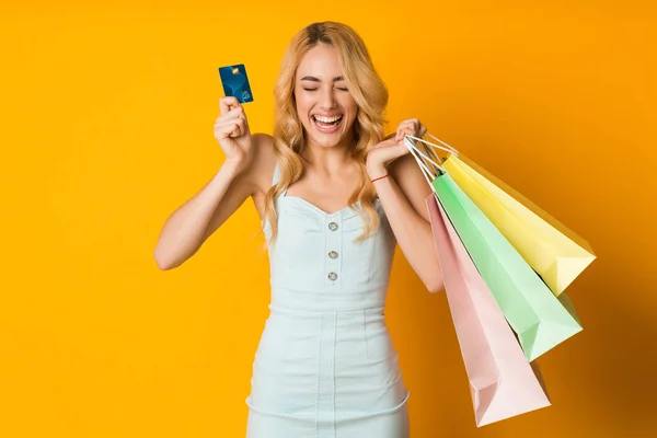 Concetto di shopping. Donna felicissima con carta di credito e sacchetti di carta — Foto Stock